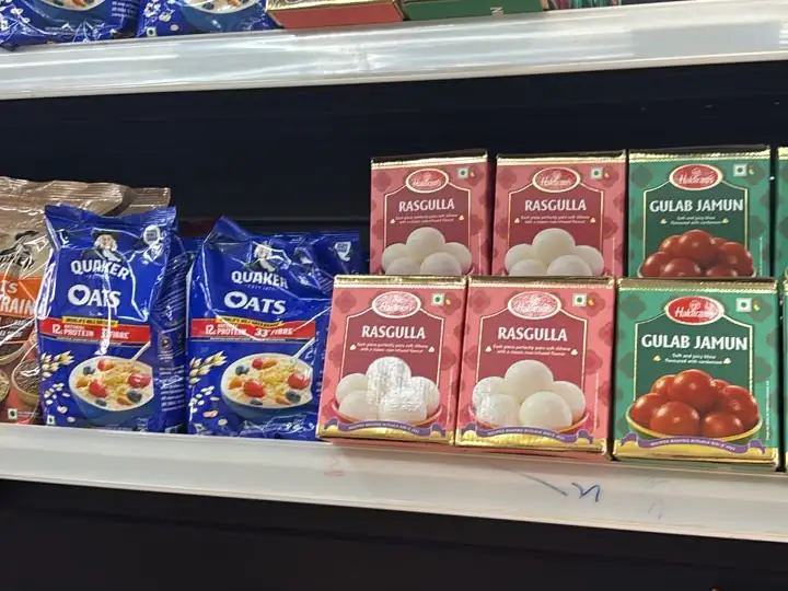 Haldiram's rasgulla and gulab jamun tins beside Quaker Oats and Unibic cookies