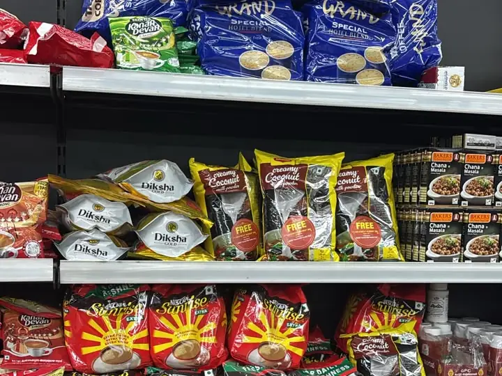Shelves of Nescafé Sunrise, Tata Tea Kanan Devan and Grand coffee packs